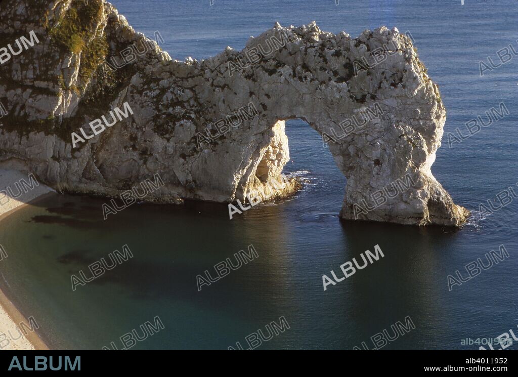 Durdle Door, Dorset, 20th century.  Natural limestone rock arch in chalk cliffs on the Jurassic Coast near Lulworth in Dorset, England. The name Durdle is derived from Old English 'thirl' meaning bore or drill  Rock-arch in chalk cliff.