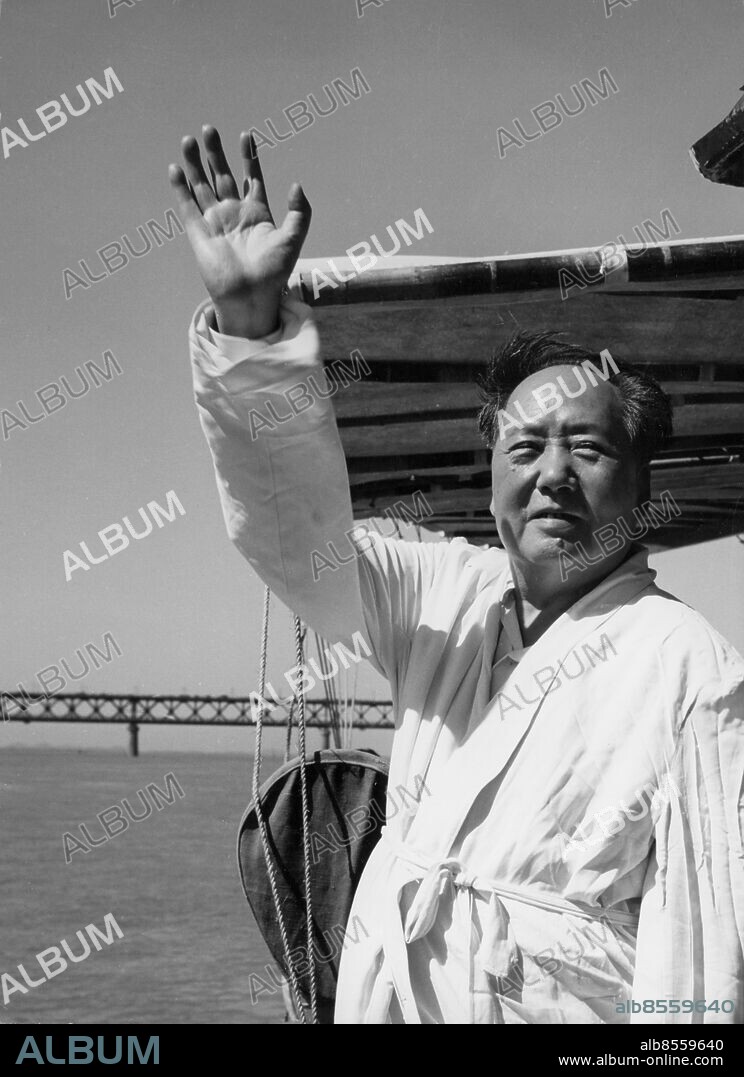 Orig. bildtext... CHAIRMAN MAO TSE-TUNG SWIMS IN YANGTZE RIVER Photo shows Chairman Mao standing on the deck of a motorboat, reviewing the swimmers who are grappling with the waves. Anm. Mao Zedong, 1893-1976, kinesisk politiker och statsman, ordförande för Kinas kommunistiska parti från 1943. Hälsningar Vinkning CD280 persons: MAO ZEDONG sites: KINA.