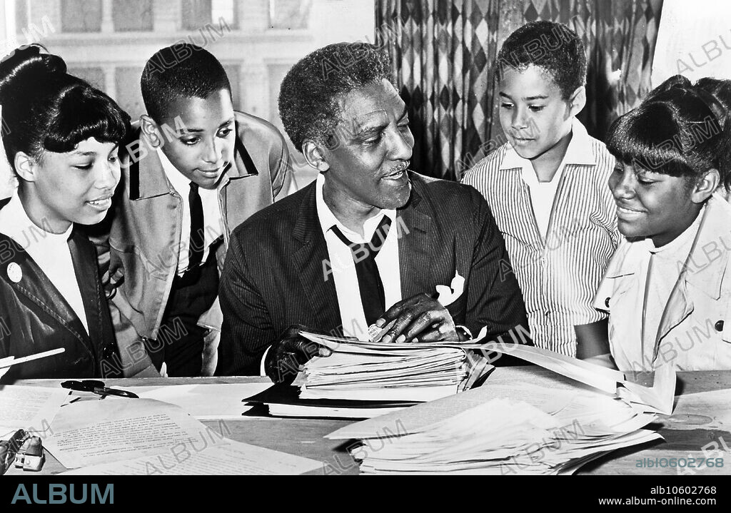 Bayard Rustin (center) speaking with (left to right) Carolyn Carter, Cecil Carter, Kurt Levister, and Kathy Ross, before demonstration, Ed Ford, New York World-Telegram and the Sun Newspaper Photograph Collection, 1964.