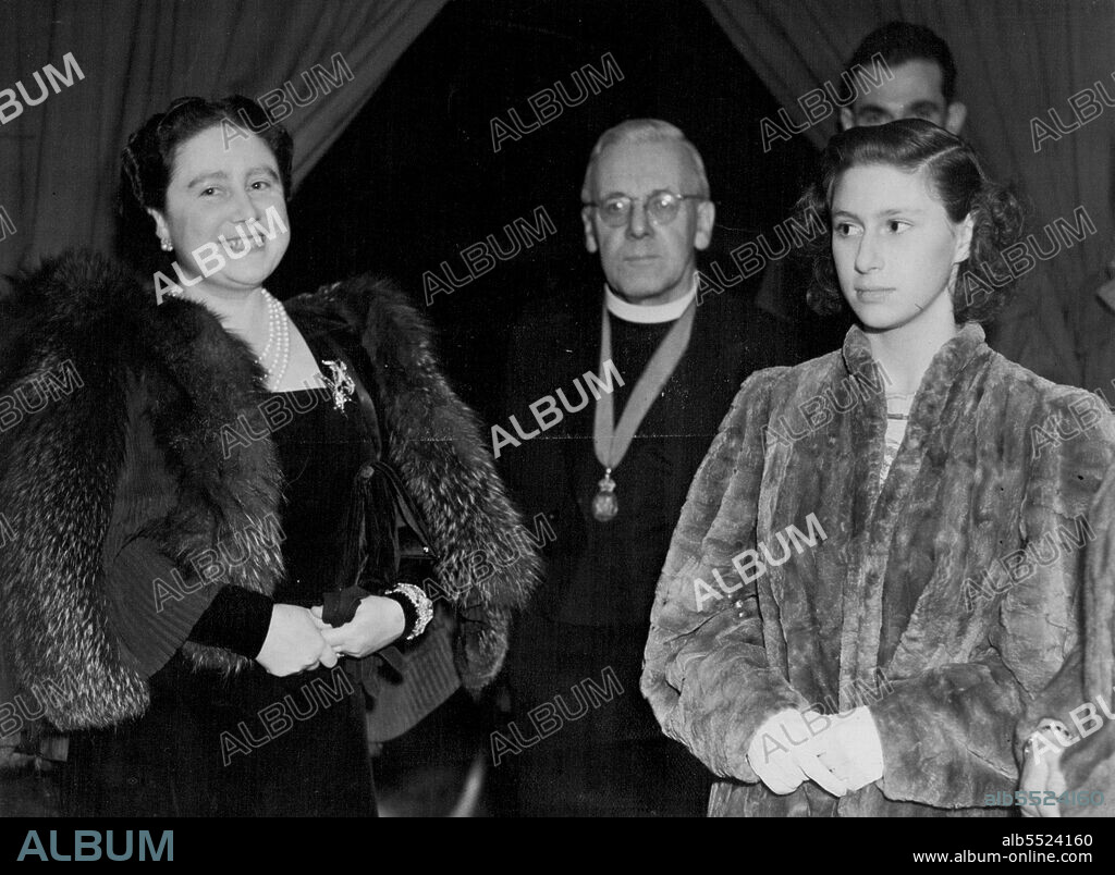 Her Majesty The Queen and Princess at Concert In Aid Of Toc H. -- The Queen, The Rev. "Tubby" Clayton and Princess Margaret Rose in the Royal Box. A concert in aid of Toc H arranged by Dr. Malcolm Sargent at the Royal Albert Hall, was attended by The Queen and Princesses. January 07, 1946. (Photo by London News Agency Photos Ltd.).