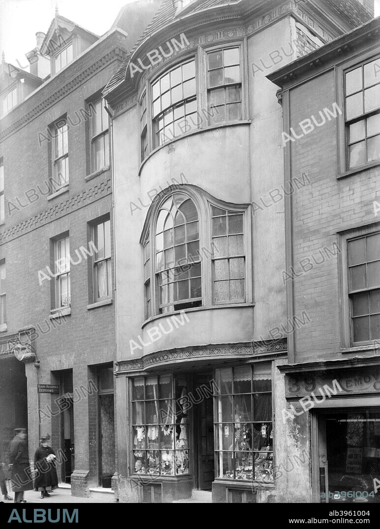 Street front of 38 High Street, Hastings, East Sussex, 1922; dating from the late 18th century. Above the shop front are two bow windows. The first floor window is a variant form of the Venetian window, arched and with gothicized interlaced glazing bars. Judging from the costume of the pedestrians, this photograph was probably taken in the late nineteenth or early twentieth century.