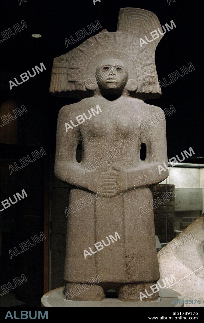 Pre-Columbian period. Huastec civilization (900-1450). Female figure depicting Tlazolteotl (Goddess of Fertility). Sandstone. Tlazolteotl is shown with her hands clasped in front, wearing semi-circular headdress with radiating "spikes" and engraved design. Panuco river, Mexico. British Museum. London, England, United Kingdom.