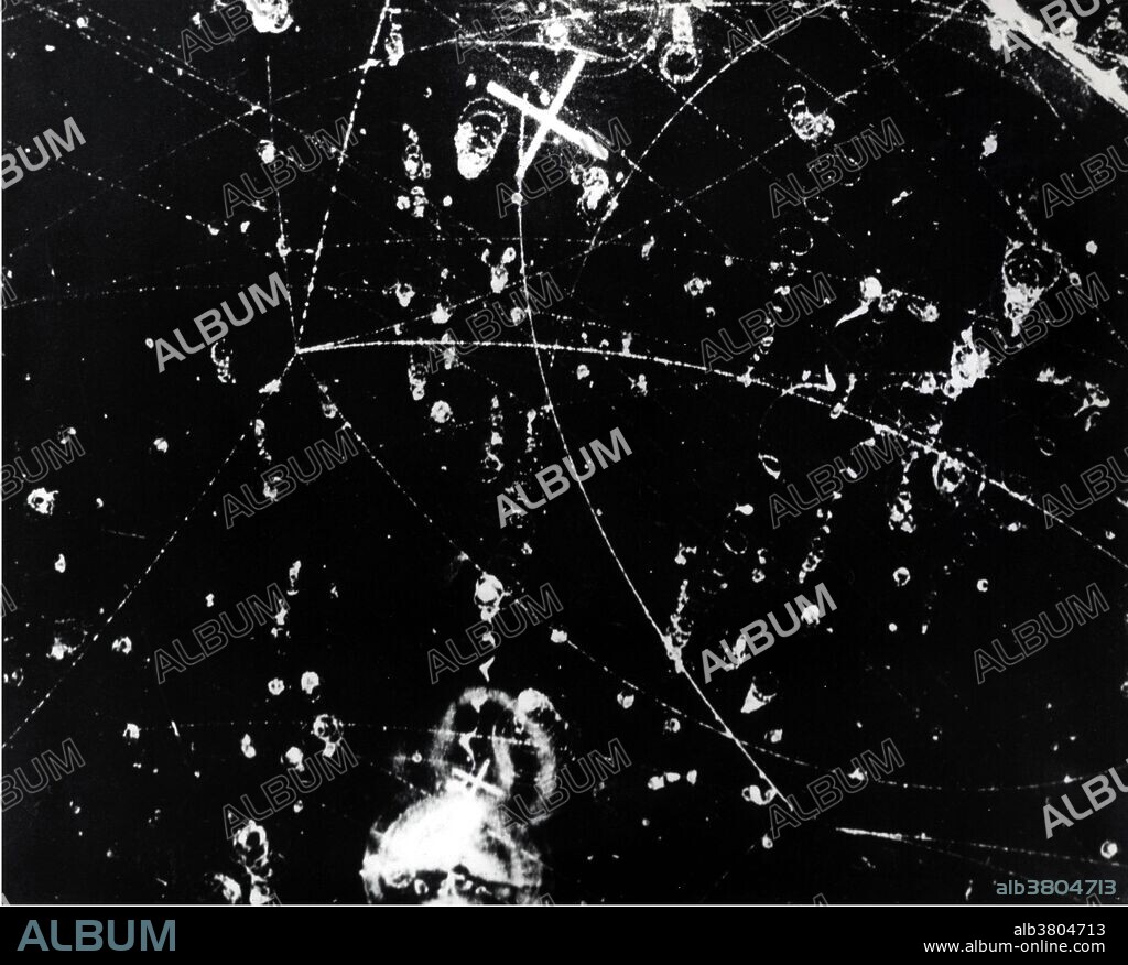 Nuclear particle tracks in the 10 inch bubble chamber mounted inside a superconducting magnet at Argonne show what happened to two negative K mesons that entered the bubble chamber from Argonne's ZGS (Zero Gradient Synchrotron), 1966. In particle physics, mesons are hadronic subatomic particles composed of one quark and one antiquark, bound together by the strong interaction. Mesons are not produced by radioactive decay, but appear in nature only as short-lived products of very high-energy interactions in matter, between particles made of quarks. A bubble chamber is a vessel filled with a superheated transparent liquid (most often liquid hydrogen) used to detect electrically charged particles moving through it. The ZGS was a 12 GeV weak-focusing proton synchrotron. It was the first synchrotron to accelerate spin polarized protons and the first to use H-minus injection.