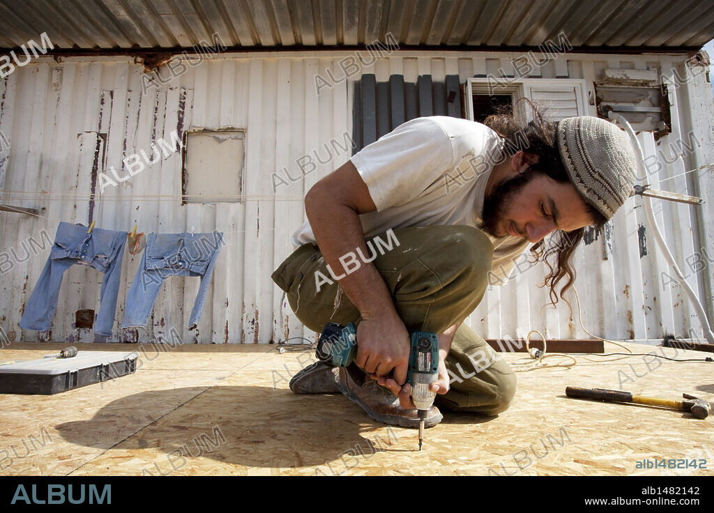 YAIR ISRAEL and MIDDLE EAST. Oct. 07, 2010 - Havat Gilad, Israel - Israeli settler YAIR ISRAEL installs flooring on an addition to a home. The small settlement is situated on land privately owned by Moshe Zar, a friend of former prime minister Ariel Sharon who gained notoriety in 1982 as a member of the Jewish Underground terrorist group. (Credit Image: © Edmund D. Fountain/St. Petersburg Times/zReportage.com/ZUMA). 07/10/2010