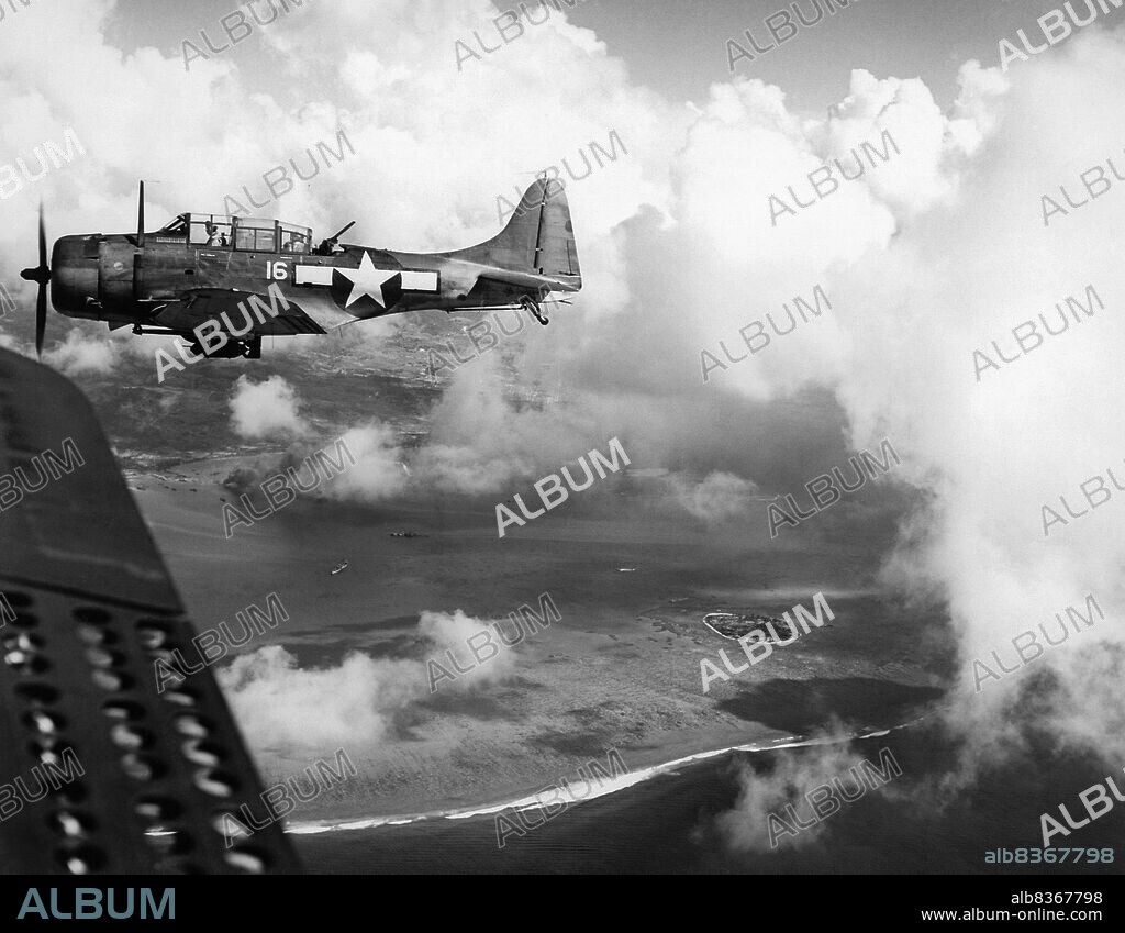 Pacific War: A US Douglas SBD Dauntless dive bomber flies over the island of Saipan on 15 June 1944. The Battle of Saipan (15 June to 9 July, 1944) was a key Pacific battle during World War II, fought between the armed forces of the United States and Japan.