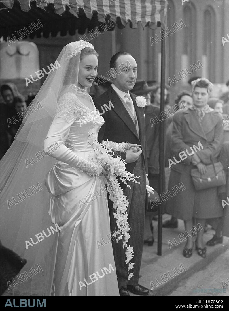 Labour M.P Marries. Mr John Lewis, Labour M.P for Bolton, was married at Hampstead synagogue, London, this afternoon (Tuesday) to Miss Joy Jocille Fletcher only daughter of Mr and Mrs Horace Fletcher, of Finchley Road, NW. Mr Lewis, who is aged 33, is the director of rubber improvements, Ltd, and is joint inventor of a process for reclamation of rubber. Born in London he is a free man and livery man of the Carmen company. Sponsor of the coal board's Championships for boxing miners, he recently led a successful attack on the boxing board of control for the revision of the colour bar in British boxing. Nearly 100 members of the Bolton Labour Party, some of them councillors, were in London today for the wedding, which was followed by a reception at the Dorchester. Picture shows: "classical bride" the smiling bride and groom leave Hampstead synagogue, after the ceremony, today. 17 February 1948.