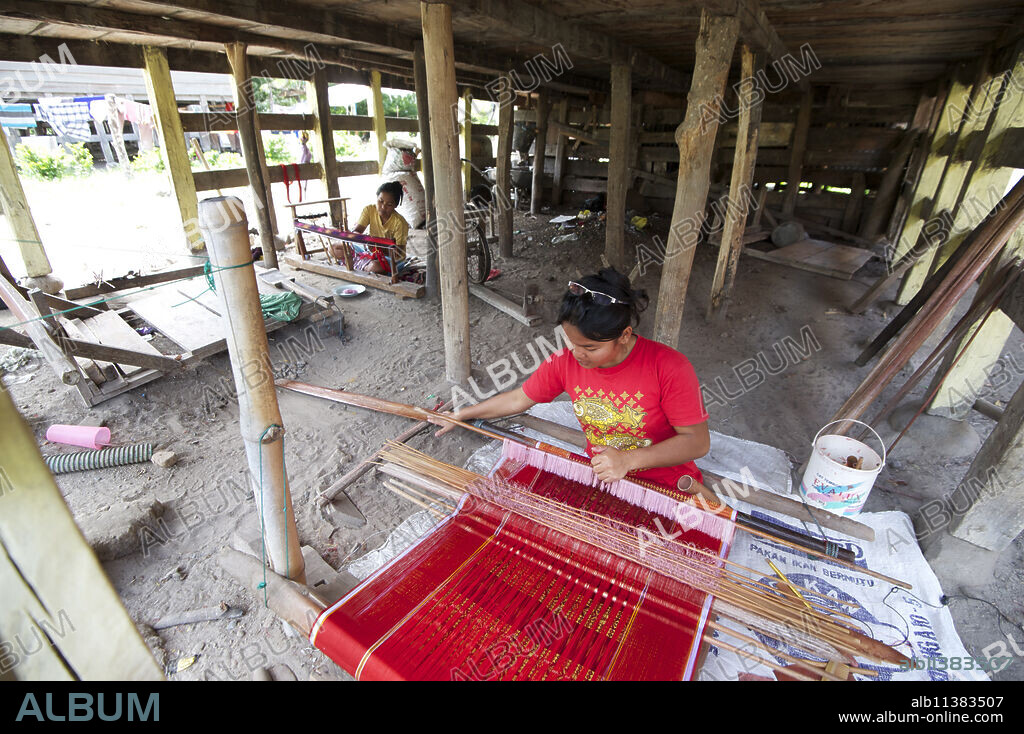 Batak woman weaving Batak Toba design sarong beneath her traditional Batak house, Buhit, Samosir Island, Lake Toba, Sumatra, Indonesia, Southeast Asia, Asia.