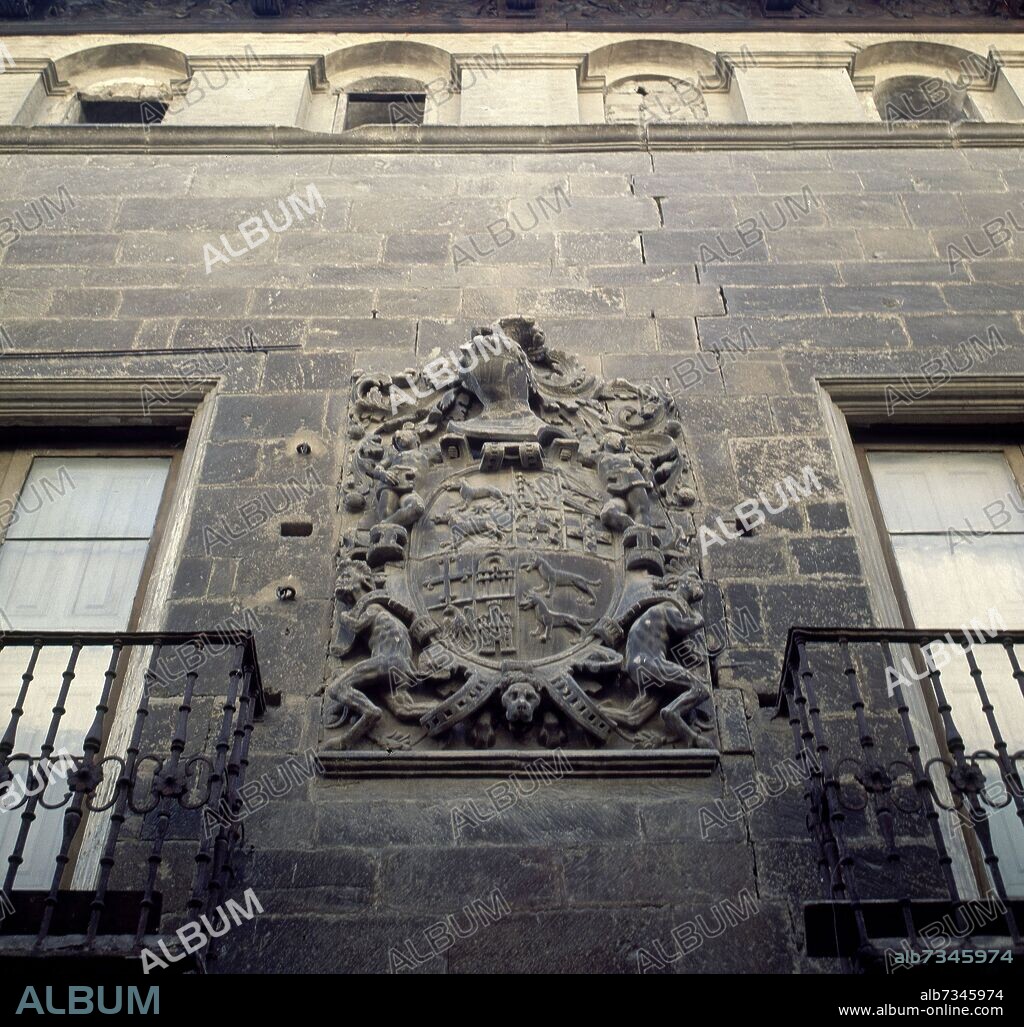 ESCUDO EN PIEDRA EN EL MURO DE UNA CASA.