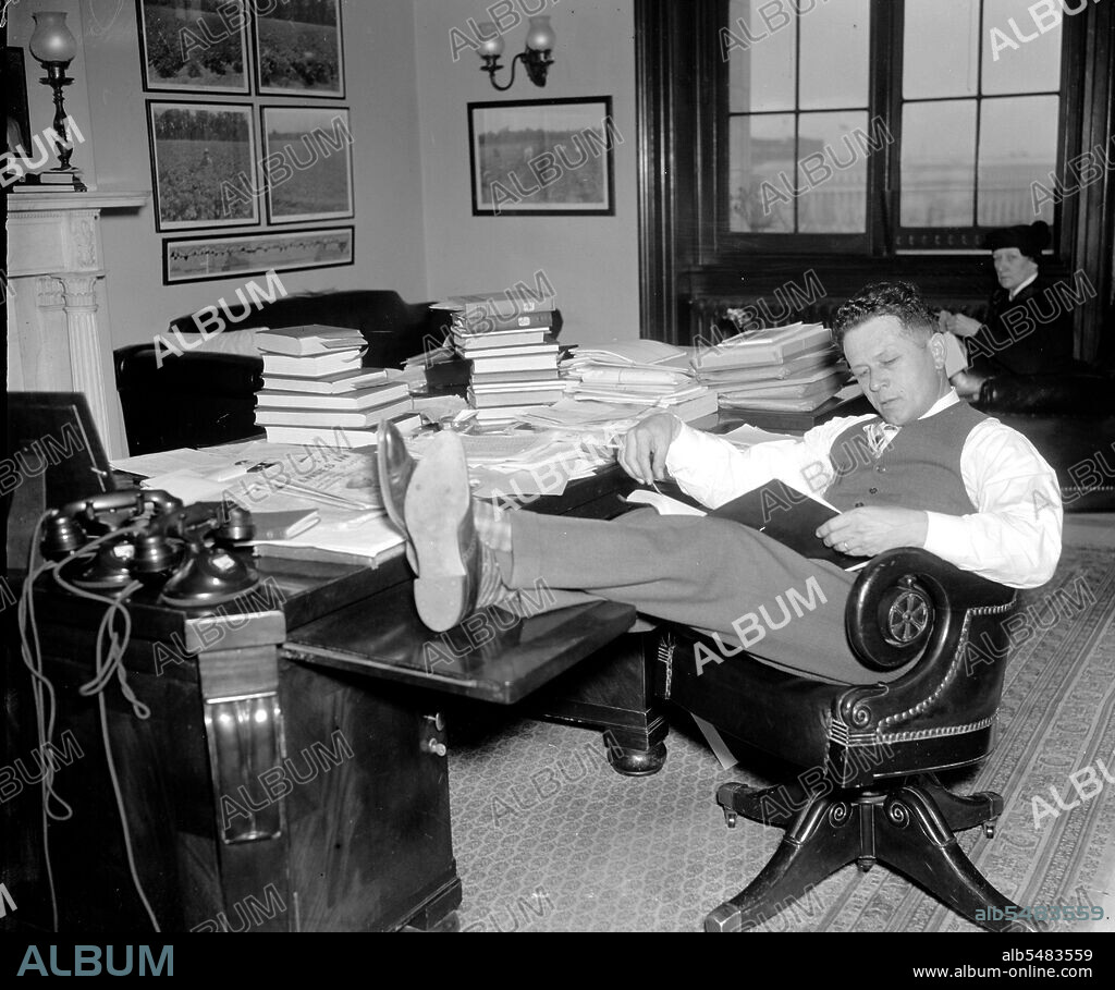1/26/1938 - Democrat Senator Allen J. Ellender, of Louisiana, rests and studies up on Senate procedure of filibuster while his colleagues continue the Filibuster against the anti-lynching bill circa 1938.