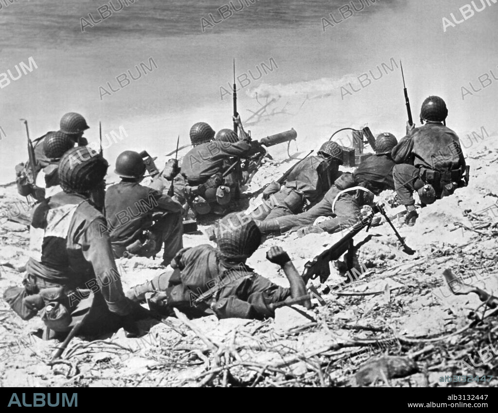 Marshall Islands:  August 11, 1944 U.S. Marines take cover behind sand dunes in the opening phase of the invasion of Eniwetok Atoll.