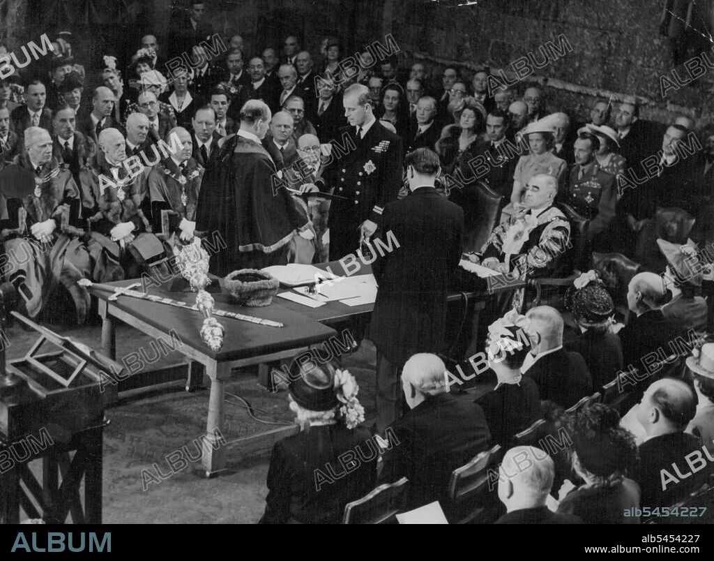 London freedom for Duke of Edinburgh -- In Naval uniform and wearing the insignia of the order of the Garter, the blond figure of Prince Philip, Duke of Edinburgh stands in London's medieval Guildhall as he takes the oath as Preeman of the city of London today, June 8. Sir Frederick Wells, Lord Mayor of London sits Robed at the table head. The city aldermen are Ranged at left. In the front Row, Foreground, are, left to right, Mrs. Winston Churchill, Winston Churchill, Mrs. Clifton Brown, colonel Clifton Brown, speaker of the house of Commons, Mrs. Clement Attlee and premier Clement Attle, who is seated next Princess Elizabeth. July 7, 1948. (Photo by Associated Press Photo).