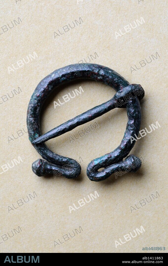 Fíbula de omega con aguja móvil hecha en bronce . Diámetro 2, 3 cm Grosor 0,3 cm Ancho 2, 1 cm ( Siglo I - III dc ) - Epoca romana , procedente de la " Casa de Hippolytus " - Yacimiento arqueológico de Complutum en Alcalá de Henares ( Madrid ). ESPAÑA .