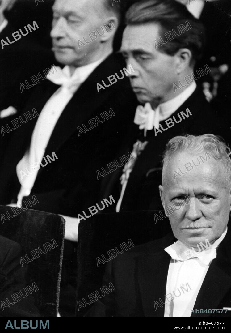 Arkiv 1965-12-10 . Michail Sjolochov (1905-1984), rysk författare som fick Nobelpriset i litteratur 1965. Hans mest kända verk är romansviten "Stilla flyter Don". Här under Nobelprisutdelningen. I bakgrunden de svenska författarna Eyvind Johnson och Karl Ragnar Gierow.. Foto: Svenskt Pressfoto Kod: 20360. Scanpix Sweden.