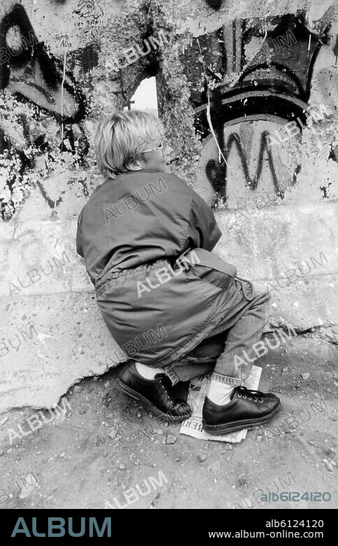 Berlin, 10./11. November 1989: Nach Öffnung der DDR-Grenzen zum Westen (9.11.1989).-Kind an einem Loch in der Mauer.-Foto.