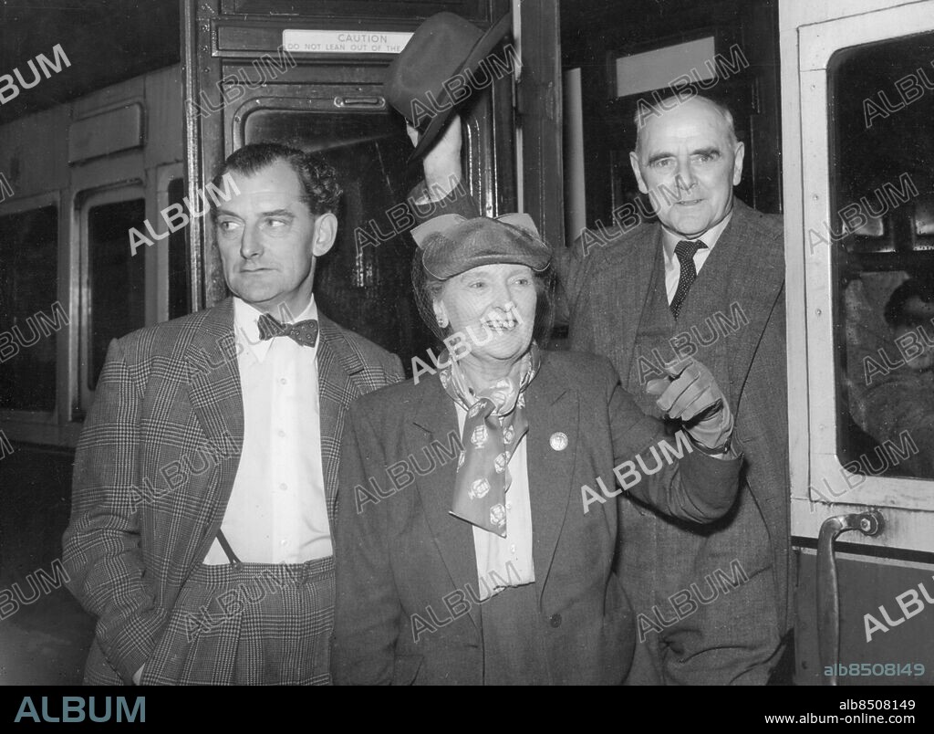 Orig. bildtext... DAME SYBIL THORNDIKE LEAVES FOR AUSTRALIA. 26.5.54 Dame Sybil Thorndike and her husband, Sir Lewis Casson, seen at Waterloo this morning before leaving in the Dominion Monrach boat train enroute to Australia, where they begin a three months' tour that also embraces New Zealand. Also seen is their son, John Casson, who is a producer in Australia, and a travelling companion on this occasion. Anm. S Thorndike, 1882-1976, engelsk skådespelare Trio Resenärer Fluga Flor CD680 persons: JOHN CASSON;LEWIS CASSON;SYBIL THORNDIKE sites: AUSTRALIEN*;LONDON;STORBRITANNIEN.