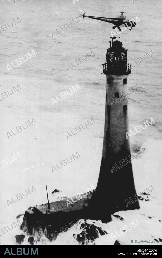 Helicopter Relieves Wolf Rock - A dramatic picture as the Helicopters hovers over the Wolf Rock lighthouse while the heavy seas surge around the base of the light-house as the food and mail are lowered to the three men on the lighthouse. Wolf Rock lighthouse, off Land's End, cut off by raging Atlantic seas for the past 26 days, was relieved yesterday - by helicopter. Guided by a circling naval aircraft, the blue and silver Trinity House helicopter, piloted by Captain Alan Bristow, approached the 135-ft, high tower and lowered three bags of food and mail to the occupants on the lamp balcony. February 8, 1948. (Photo by Reuterphoto).
