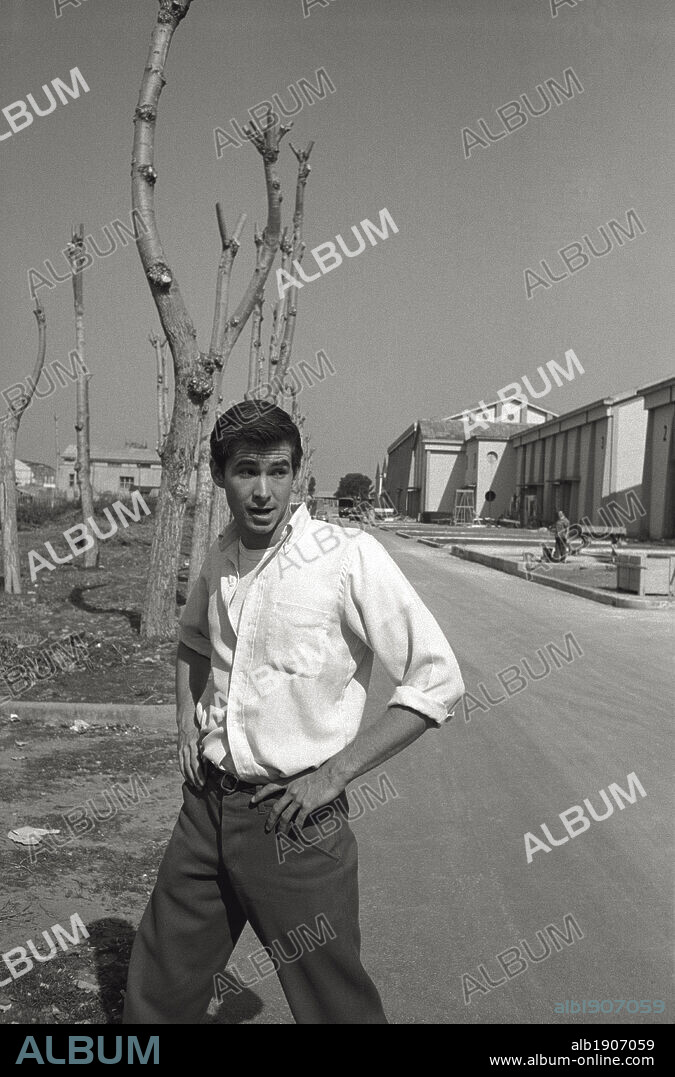 Anthony Perkins is walking in Cinecittà. The US actor Anthony Perkins, best known for playing Norman Bates, the serial killer of the film 'Psycho' directed by Alfred Hitchcock, is walking in the park of Cinecittà studios. Rome, March 1957.