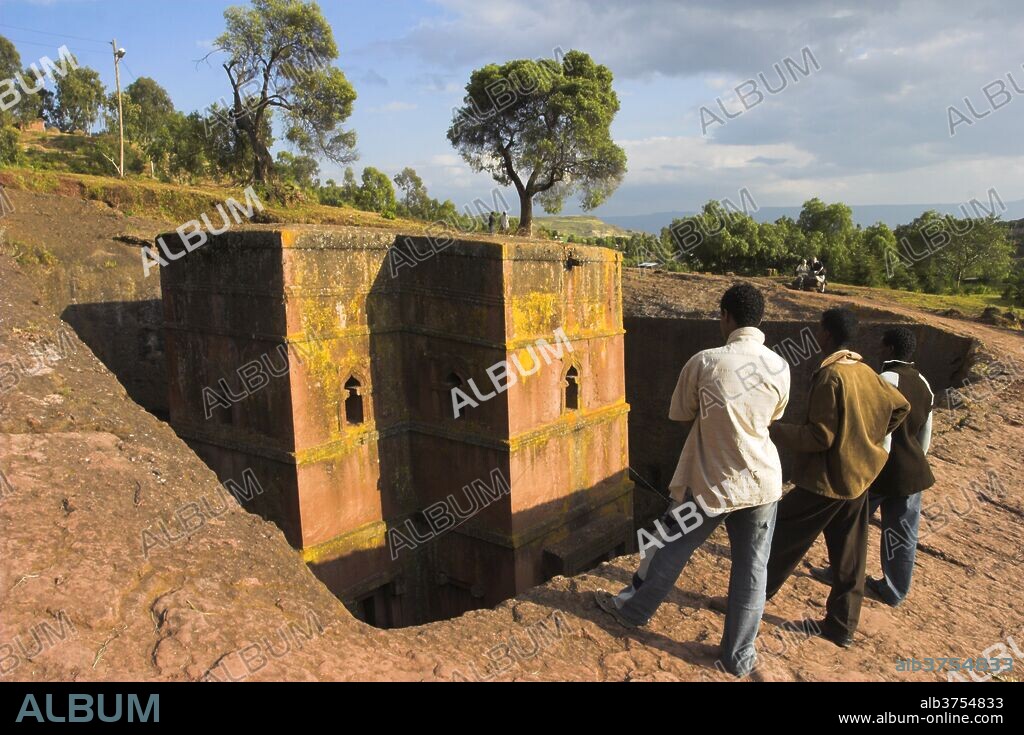 Men looking at rock-hewn monolithic church of Bet Giyorgis (St. George's), 40 feet in height with roof shaped like a Greek cross, the most famous of Lalibela's churches, UNESCO World Heritage Site, Lalibela, Ethiopia, AFrica.