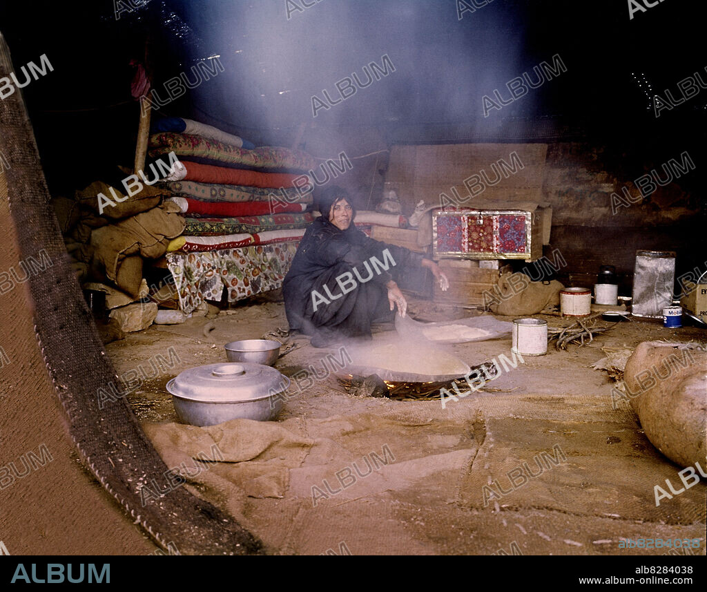 BEDUINA EN EL DESIERTO EN SU HAIMA CONDIMENTANDO ARROZ.