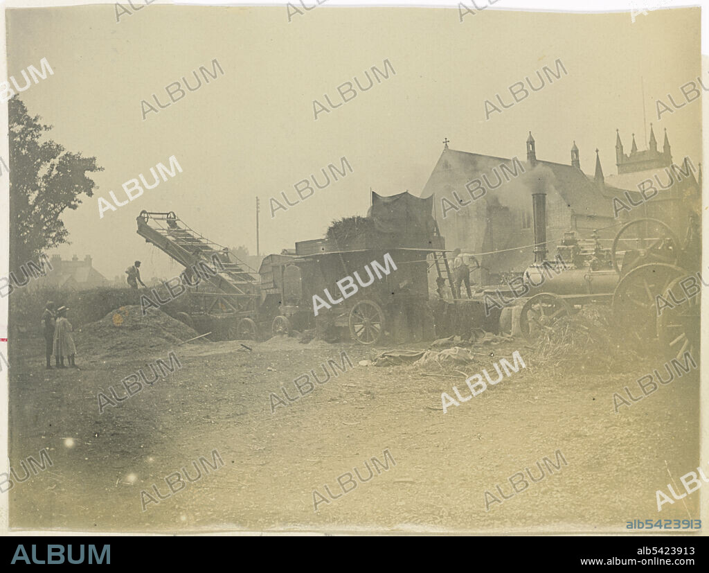 St Marys Church, Church Street, Littlehampton, Arun, West Sussex, 1901-1902. People at work using a steam powered threshing machine, with St Mary's Church in the background. Photographed as part of a series recording the Holborn and Strand improvement works. St Mary's Church was extended eastwards in the late 19th century, with a new chancel and Lady Chapel, however by 1930 the structural condition of the church was so bad that it had to be demolished. This photograph shows the building with the late 19th century extension.