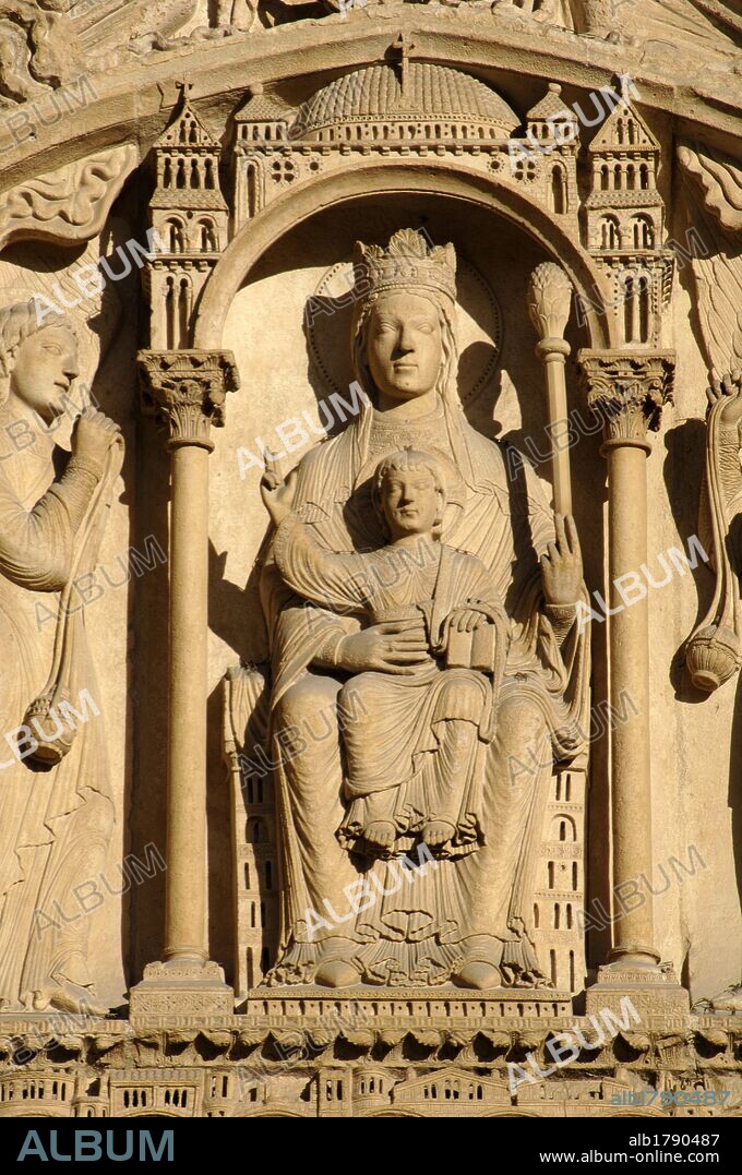 France. Pari_s. Notre Dame cathedral. Portal of St. Anne. Tympanum (c. 1150). Romanesque. Virgin and Child. Mary is enthroned under a canopy, wearing a crown and holding a sceptre; the Christ Child holds the Book of the Law and raises one hand in blessing. On either side of the throne are angels with censers.