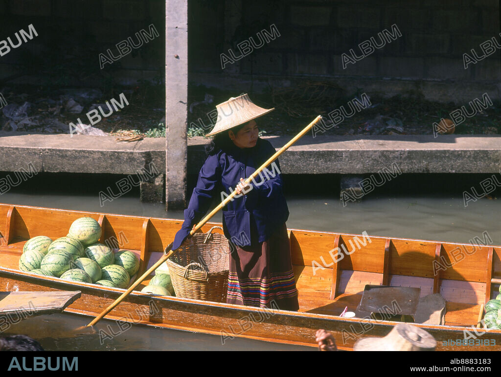 MUJER DIRIJE SU CANOA CON MELONES.