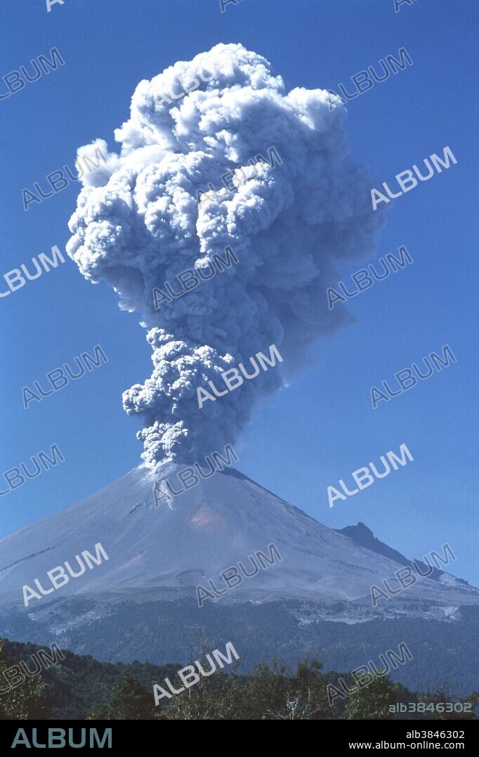 Popocatepetl volcano erupting. This volcano (5452 meters elevation) is the second-highest peak in Mexico. It had been dormant for around 60 years when it became active again in 1994. Moderate eruptions and earthquakes have occurred every few months, as of early 2001. As here, these can be accompanied by a column of ash and gas rising for several kilometers into the sky, posing a hazard to aviation. The largest eruption for 1000 years occurred in December 2000. Monitoring of the volcano and evacuation alerts help to protect the surrounding population. Photographed in December 1998.