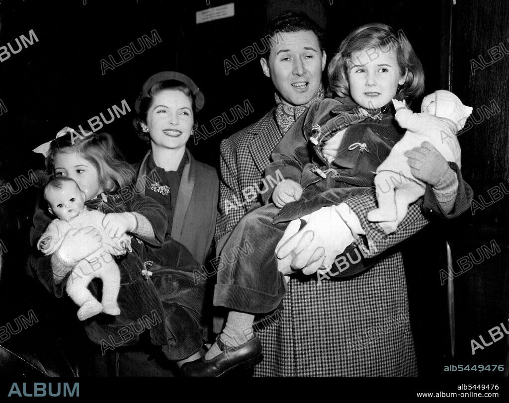 Quayle Family Off On Australasian Tour -- Mr. and Mrs. Anthony Quayle with their children on departure from Liverpool Street that Mrs. Quayle (Dorothy Hyson) is ***** Jennifer, 2½; Mr. Quayle is holding Rosanna, 4½.Members of a company of 30 artists and technicians from the Shakespeare Memorial Theatre, Stratford-on-Avon, left Liverpool Street Station, London, to-day (Tuesday) to board the New Zealand Shipping Company's liner Rangitikei at Royal Albert Dock, London. They are off on a nine-month tour of New Zealand and Australia under the leadership of Mr. Anthony Quayle (co-director with Glen Byan Shew of the Memorial Theatre). December 23, 1952. (Photo by Reuterphoto).