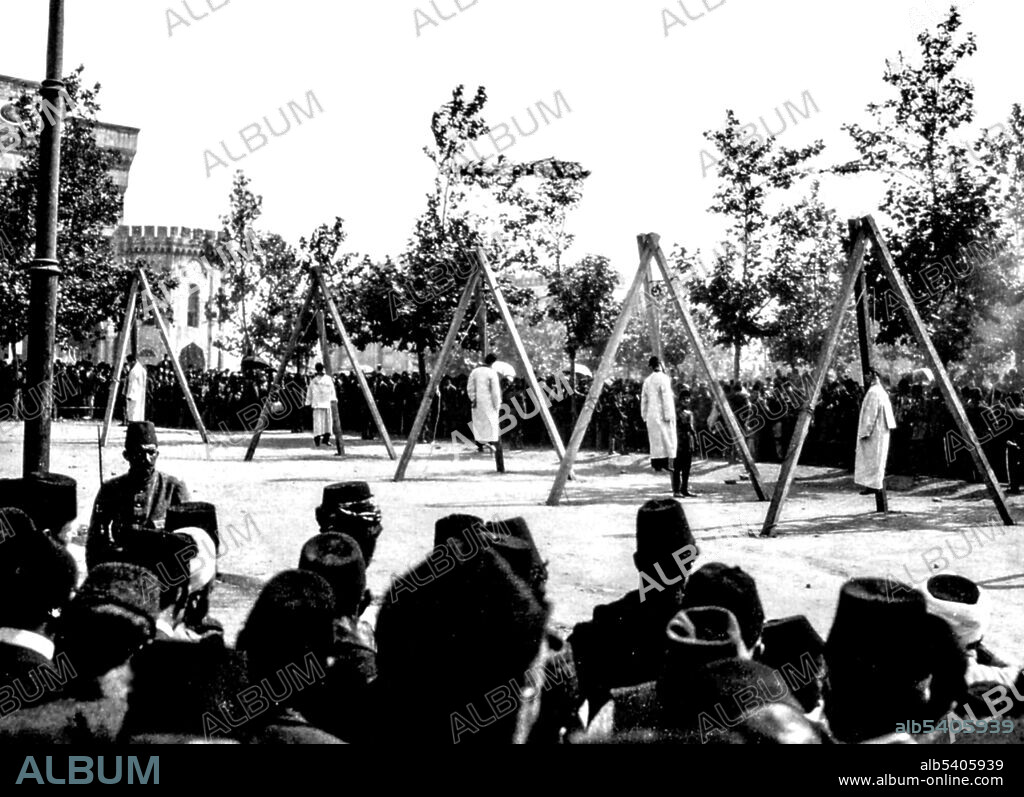 The 20 Hunchakian gallows (The 20 Martyrs) refers to the group of Hunchakian activists who were hanged during the Armenian Genocide. After spending two years in terrible conditions in Ottoman prisons, and undergoing lengthy mock trials, twenty prominent figures were sentenced to death by hanging. A few weeks after the beginning of the Armenian Genocide on June 15, 1915, all twenty men were hanged in the central square of Constantinople, known as Sultan Bayazid Square. The Armenian Genocide was the Ottoman government's systematic extermination of 1.5 million Armenians, mostly citizens within the Ottoman Empire. The genocide was carried out during and after WWI and implemented in two phases: the wholesale killing of the able-bodied male population through massacre and subjection of army conscripts to forced labor, followed by the deportation of women, children, the elderly, and the infirm on death marches leading to the Syrian Desert. The deportees were deprived of food and water and subjected to periodic robbery, rape, and massacre. No photographer credited, 1915.