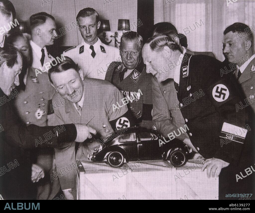 HITLER OBSERVANDO UNA MAQUETA DE UN COCHE DE LA MARCA VOLKSWAGEN.