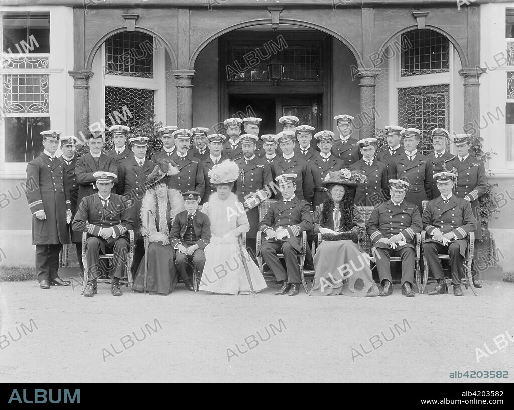 The Prince and Princess of Wales, Princess Victoria and Prince Edward at the Royal Naval College, Osborne, Isle of Wight, 1908. Group portrait of the Prince of Wales (1865-1936, later King George V) and Princess of Wales (1867-1963) with their son Prince Edward (1894-1972, later King Edward VIII). The Prince of Wales wears the uniform of a naval officer, and Edward is in cadet's uniform. He spent two years at the college. Princess Victoria (1868-1935) was Edward's aunt. Officers of Royal Naval College include Admiral Arthur Henry Christian (1863-1926), and Admiral John Arbuthnot Fisher, 1st Baron Fisher (1841-1920).