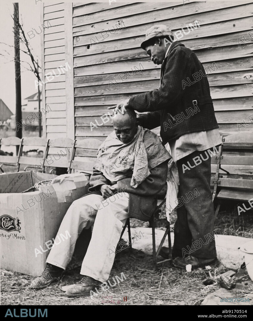 RUSSELL LEE und FARM SECURITY ADMINISTRATION. Negro getting a haircut in front of church which houses flood refugees. Sikeston, Missouri, 1937-02.