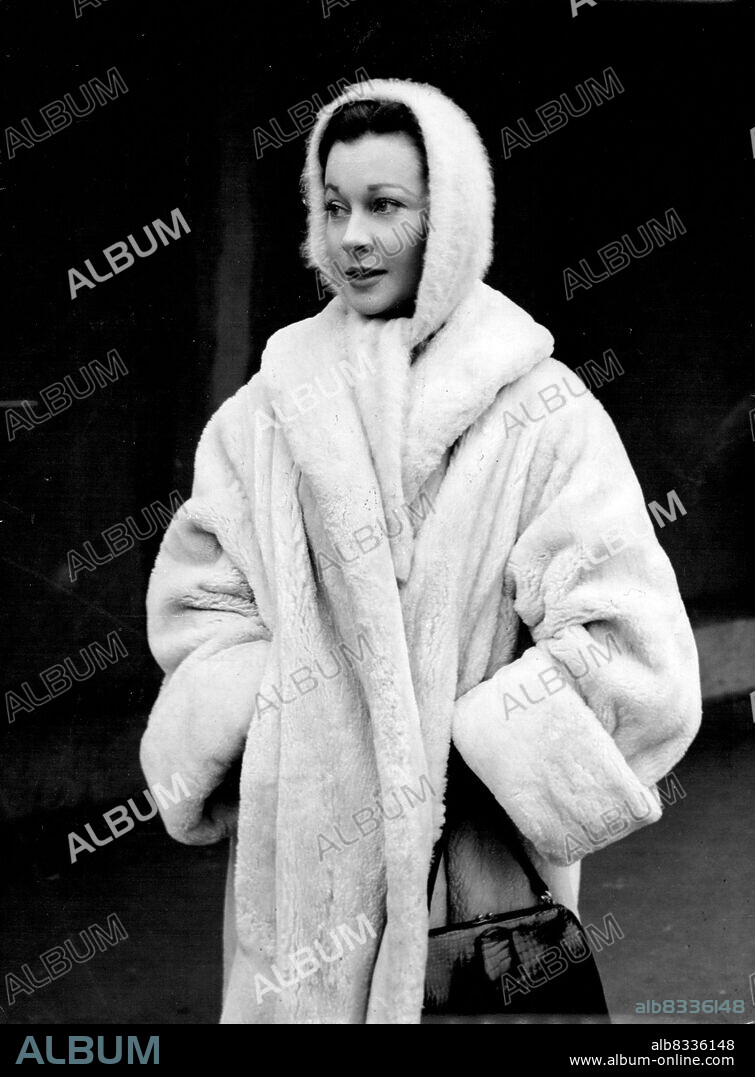 Arctic Britain brings appropriate dress by film star Vivien Leigh, who ***** into a cosy-looking white lamb coat and woolen, hand-hugging cap and scarf on the way to luncheon at Shepperton Studios, Middlesex, where she was just started work - on the London Films presentation 'The Deep Blue Sea.' Appearing in the film with her are Kenneth here, Eric Portman and Emlyn Williams. January 18, 1955. (Photo by Reuterphoto).