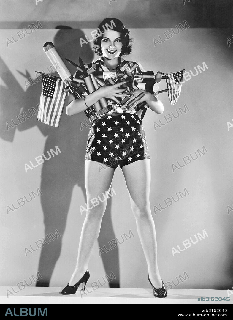 Hollywood, California: c. 1930. MGM actress Lilian Bond with an armload of fireworks for a Fourth of July celebration.