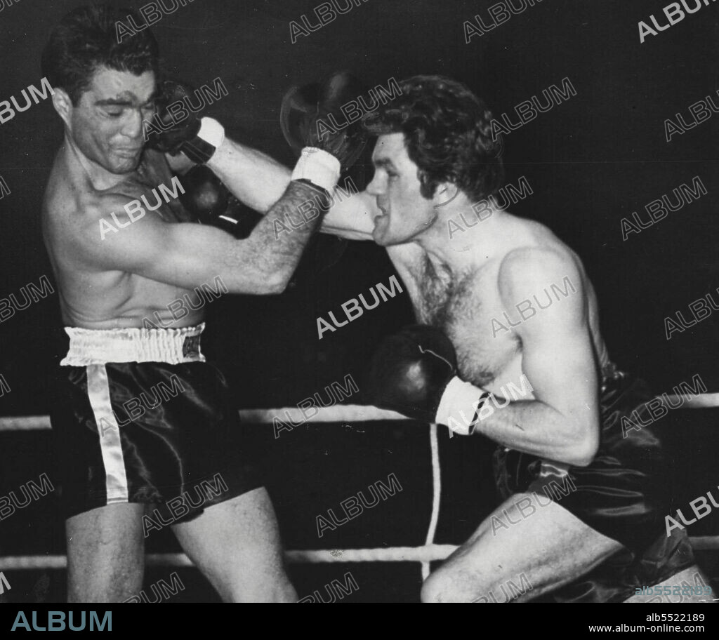 Freddie Mills V Joey Maxim....World light heavy-weight title fight at Earl's court tonight..Round I, of the Big Fight Mills (right) goes in with a right to Maxim's jaw, but the American swings up a right to fend him off. Maxim was watchful, cautious.Freddie Mills in typically aggressive mood against Joey Maxim. January 24, 1950. (Photo by Paul Popper Ltd.).