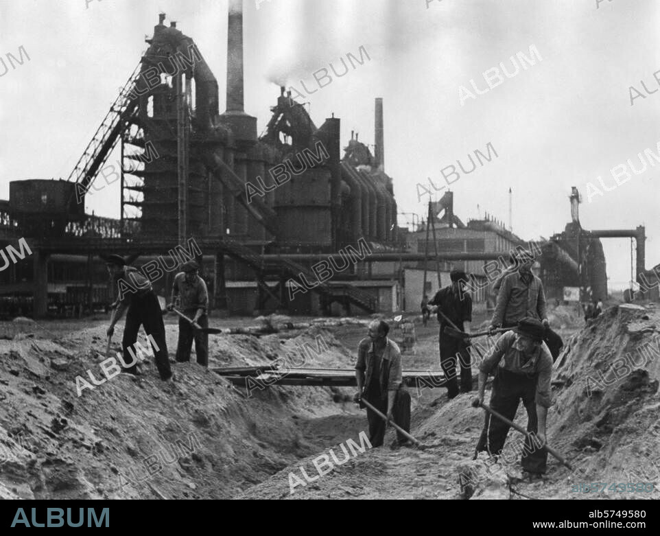 Verkehr:. Straße / Straßenbau. Arbeiter der Brigade 255 Gleis- und Straßenbau auf dem Gelände des EKO - Eisenhüttenkombinats, Fürstenberg / Oder, DDR, bei Erdarbeiten. Foto, Abraham Pisarek, undat. (um 1950).