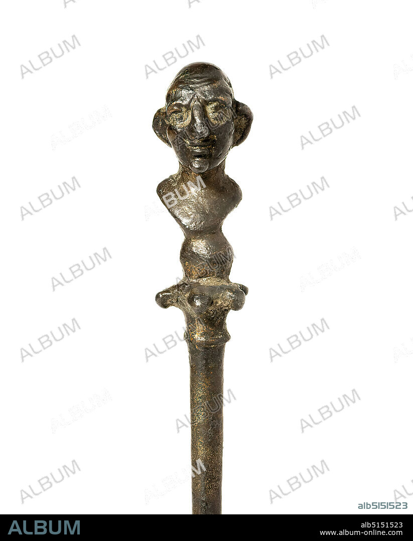 Needle with slave bust, silver, gold, cast, chased, silver, remains of gilding, Total: Height: 4.8 cm; Height: 1.9 cm (bust); Width: 0.9 cm; Depth: 1.1 cm, garment decoration, man, types of people, Middle Imperial period, needle shaft and crowning of this garment needle are cast in one piece. The lower end is broken off. Remains of the former gilding are partially preserved. A bust of an elderly man with a pointed chin, wrinkled forehead, large protruding ears and a bald skull with a braided mop of hair (lat. cirrus) can be recognized on a five-petalled capital and a globe. On the back of the bust there is a ring eyelet. The representation is grotesquely distorted and should rather be seen as an apotropaic image of hunchbacked beggars and slaves.
