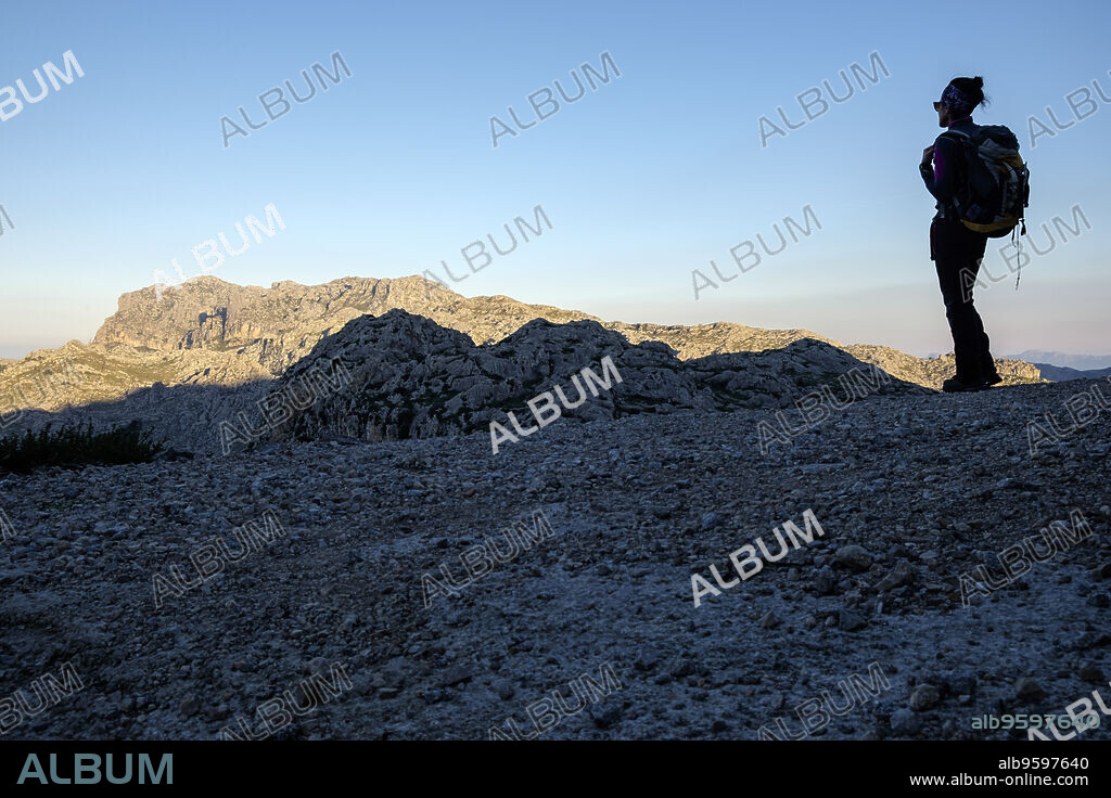 Hiker in front of Puig Gros de Ternellas, 838 m, Mortix public estate, Escorca, Mallorca, Balearic Islands, Spain.