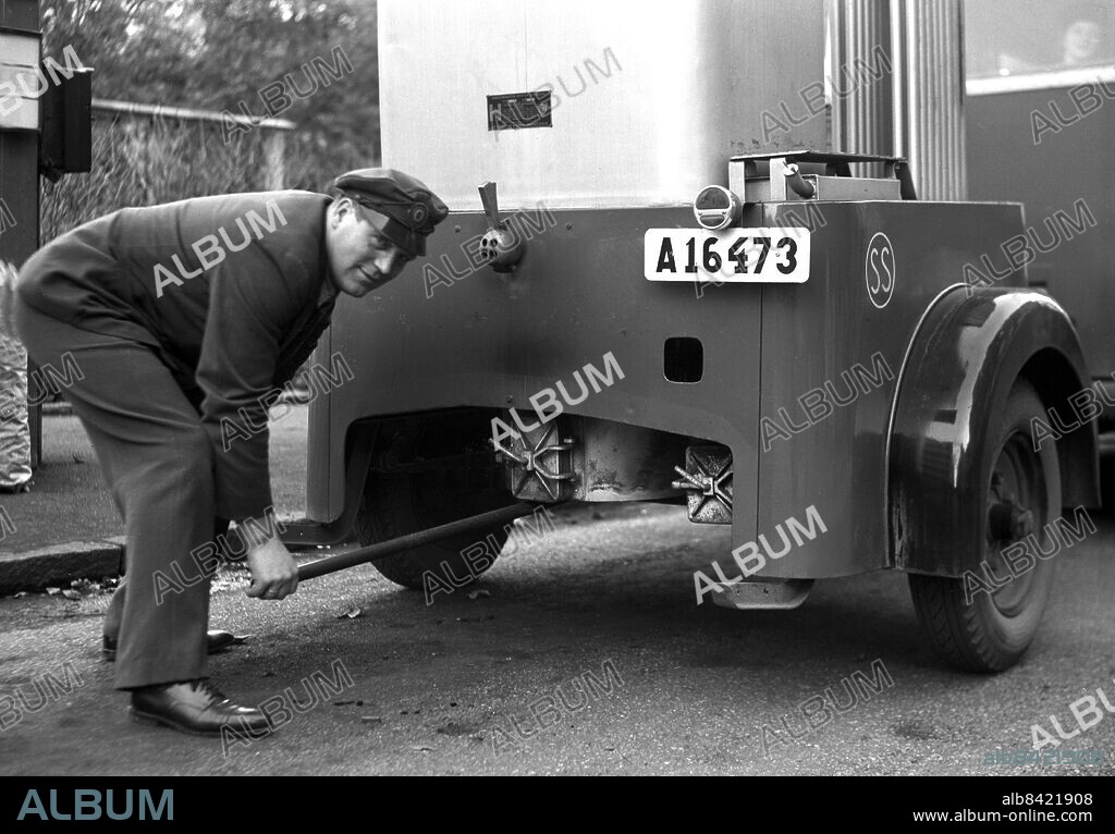 ARKIV 1940 . Chaufför startar gengasaggregatet på sin buss. Gengas är en förkortning av generatorgas som används som fordonsbränsle. Under andra världskriget utvecklades och serieproducerades små gengasaggregat för bilar och bussar i Sverige och andra isolerade länder. Driver starts the wood gas maschine on a bus.. Foto: TT / Kod 1900.