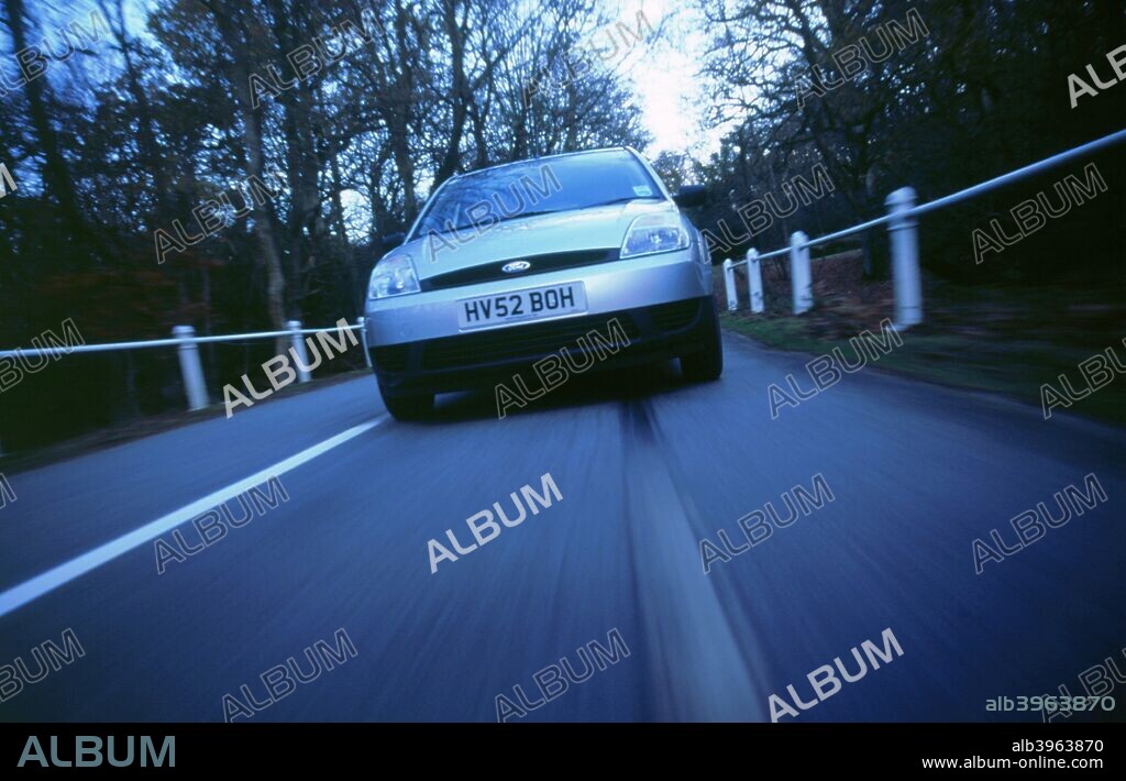 2002 Ford Fiesta driving along country road.
