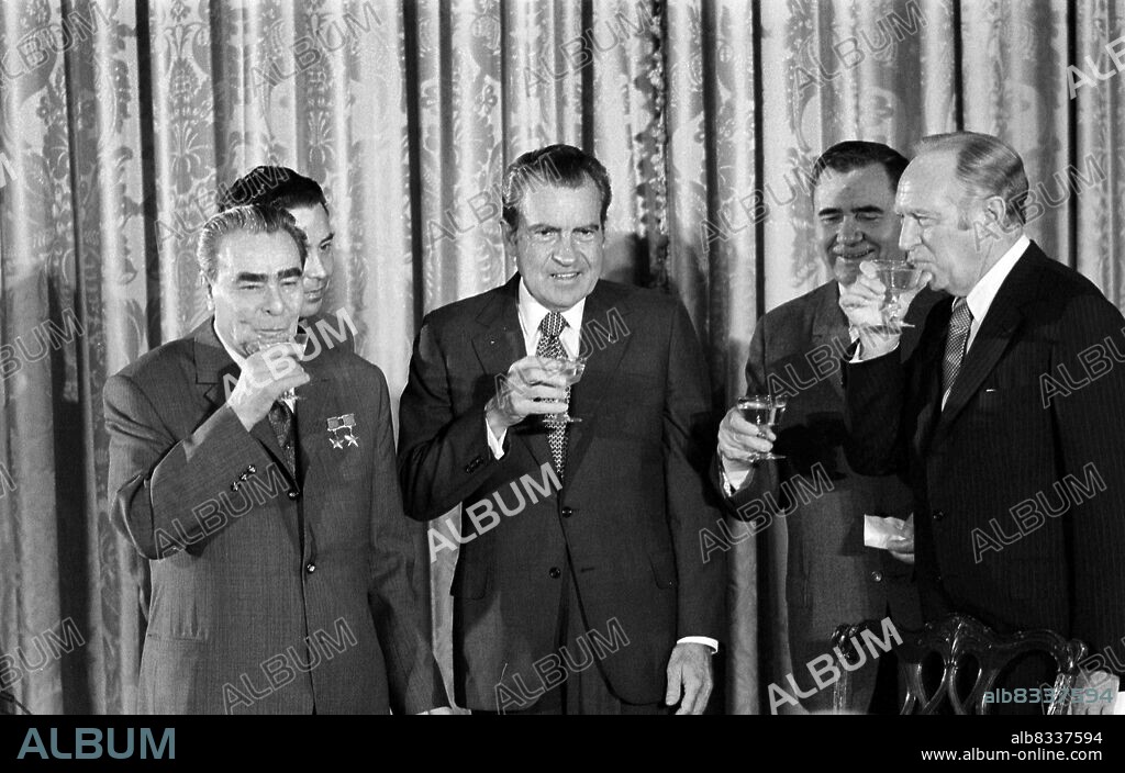 President Richard Nixon and Soviet leader Leonid Brezhnev seated in the White House, portrait of George Washington in the background, 1973.