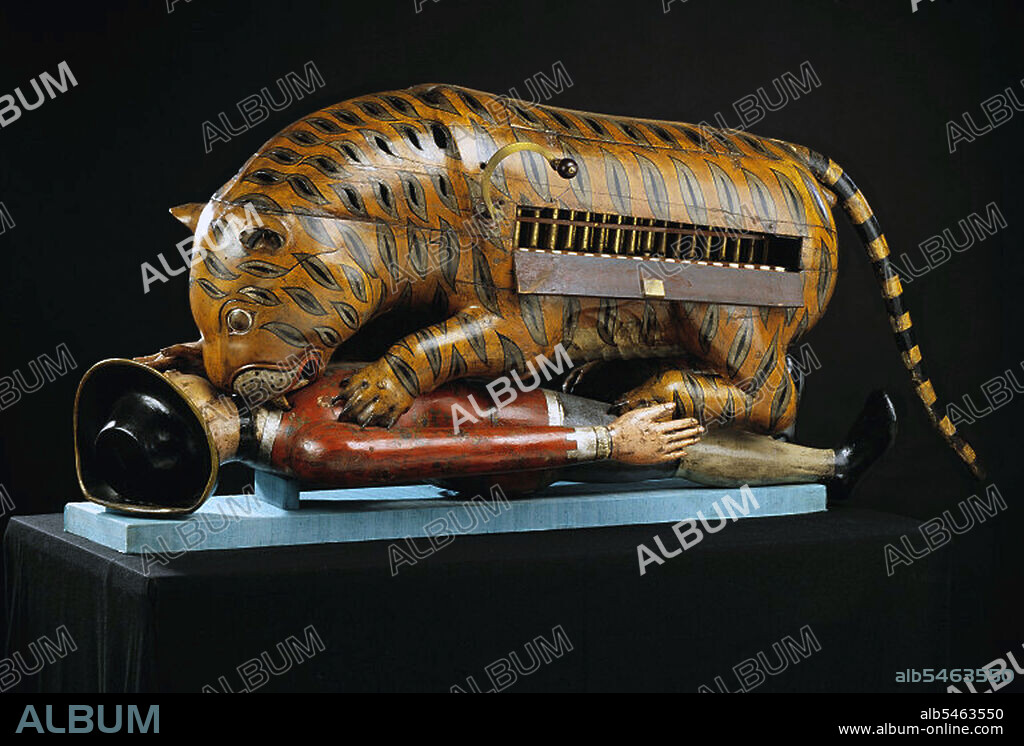 Tipu's Tiger belonged to Tipu Sultan, ruler of Mysore (1782-1799). The almost life-size wooden automaton represents a tiger mauling a prostrate figure in European clothes. There is an organ inside the tiger's body. When a handle is turned, the organ plays and the victim's arm rises and falls. The tiger was taken by the British from the palace at Mysorel after the Siege of Seringapatam in 1799. It was sent to the headquarters of the East India Company in London where it was exhibited. It was later transferred to the Victoria and Albert Museum in South Kensingtion.