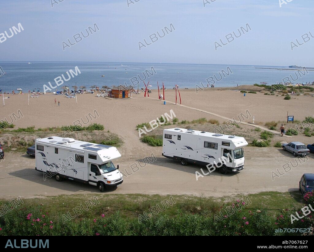 AUTOCARAVANAS CON PLACAS SOLARES APARCADAS EN LA PLAYA DE DENIA.