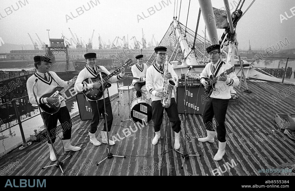 GÖTEBORG 1965-04.. TWISTBANDSTÄVLINGEN presenteras av Carl Eiwar. I dag: Semifinal i Sydsverige. Sänt första gången 1965-05-04 Reportage inför programmet i RiR 18/65 s. 10-11 och s. 45. Liknande bild publ i RiR 18/65 s. 11. Anm. Bandets vokalist, Stig Källstedt, deltog inte, då tävlingreglerna satte gränsen vid fem man. Popband Saxofoner Gitarrer Trummor Kepsar Stövlar Högtalare Mikrofonstativ Stickade tröjor V-ringat persons: HANS NIELSEN;GEORGE ANULF;BOSSE CARLSSON;LARS-GUNNAR PETTERSSON;KJELL DOVSTEDT;THE TRONICS sites: GÖTEBORG;SVERIGE.
