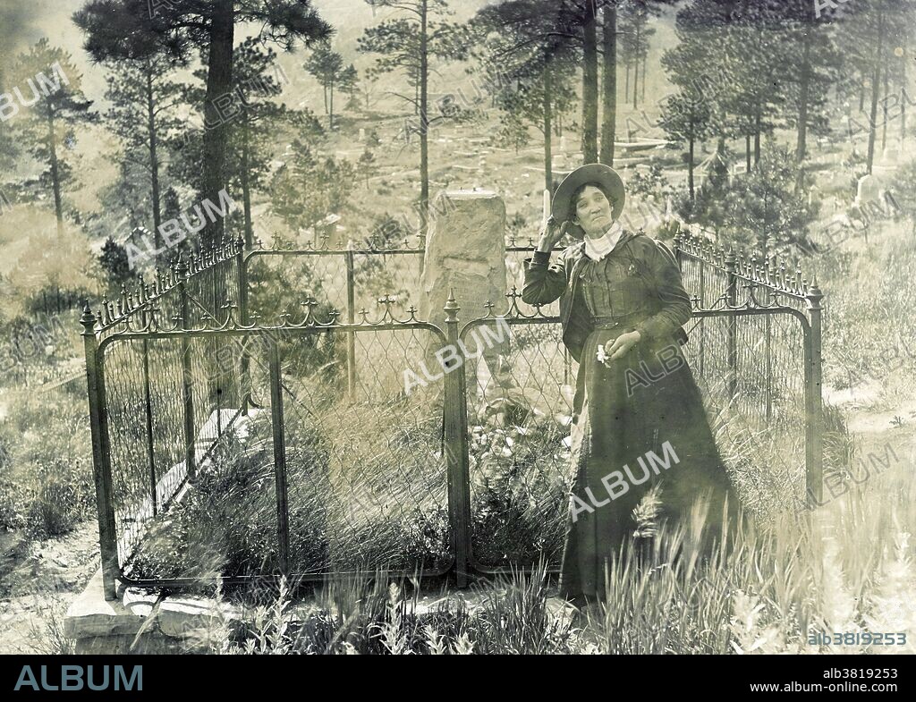 Calamity Jane, standing by the grave of Wild Bill Hickok, photogrpahed by J.A. Kumpf, 1903. Martha Jane Canary (May 1, 1852 - August 1, 1903), better known as Calamity Jane, was an American frontierswoman and professional scout. She received little to no formal education and was illiterate. She worked as a dishwasher, a cook, a waitress, a dance-hall girl, a nurse, and an ox team driver. In 1874, she found work as a scout at Fort Russell. In 1876, she settled in the area of Deadwood and became friendly with Wild Bill Hickok and Charlie Utter. After Hickok's death she continued living in the Deadwood and in late 1876 or 1878, she nursed the victims of a smallpox epidemic. In 1881, she bought a ranch in Montana, along the Yellowstone River, where she kept an inn. In 1893, she started to appear in Buffalo Bill's Wild West as a storyteller. She also participated in the 1901 Pan-American Exposition. She returned to the Black Hills in the early spring of 1903. It was reported that she had been drinking heavily on board the train and became very sick to her stomach. She died soon afterward from inflammation of the bowels and pneumonia. She was buried at Mount Moriah Cemetery, South Dakota, next to Wild Bill Hickok.