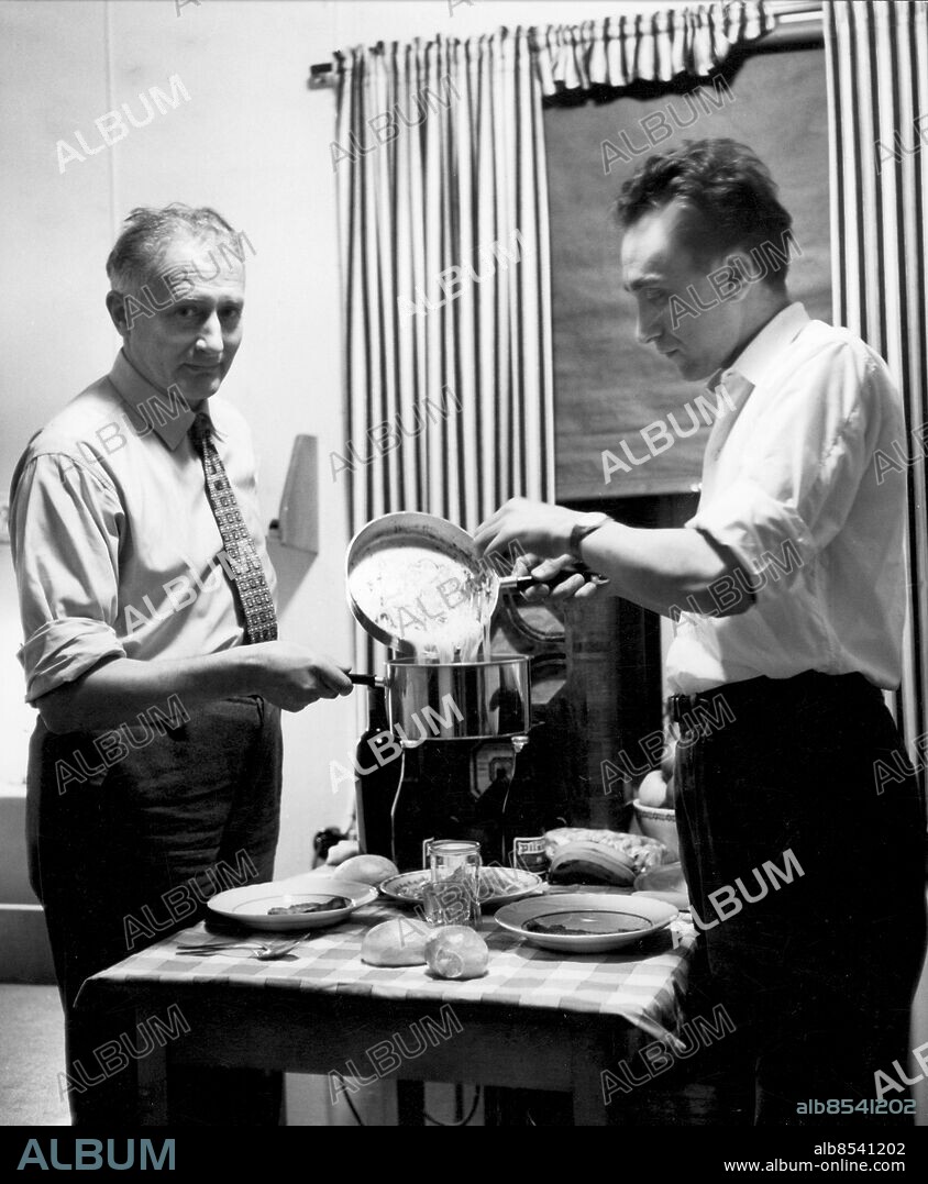VÄSTERÅS 1956.. Orig. bildtext... ITALIENARE I VÄSTERÅS PROGRAM DEN 21/2 56 Anm. Liknande bild publicerad i RiR 8/56 s4-5: Två nykomlingar i den italienska kolonin i Västerås, som ännu inte riktigt hunnit vänja sig vid de svenska köttbullarna och potatisen. I ungkarlsbaracken vid Köpingsvägen, som tjänar som genomgångsbostad, lagar de till sin spagetti och sin sallad på tomater, lök, olja och vinäger och sköljer ner måltiden med vin. Arbetskraftsinvandring ASEA L10 sites: ITALIEN* ;SVERIGE ;VÄSTERÅS.
