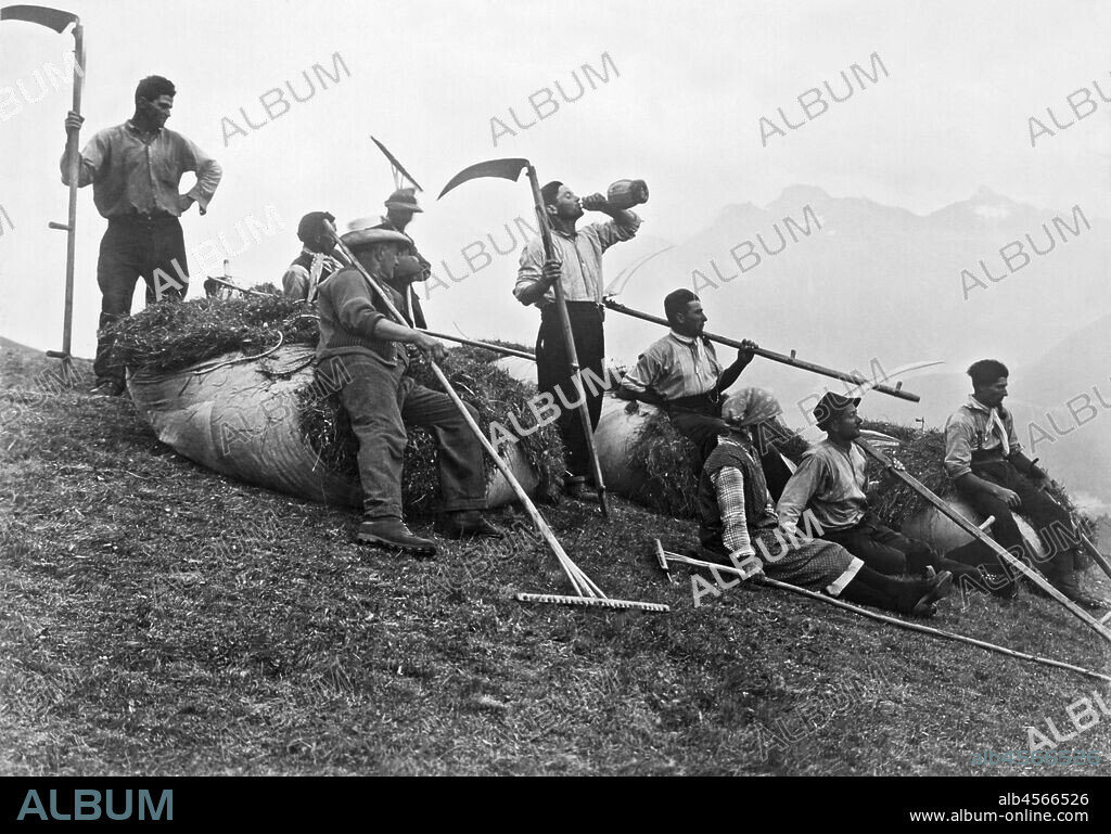 St. Moritz, Switzerland,  1931 A party of hay makers pause on the mountain side for a rest and refreshments.