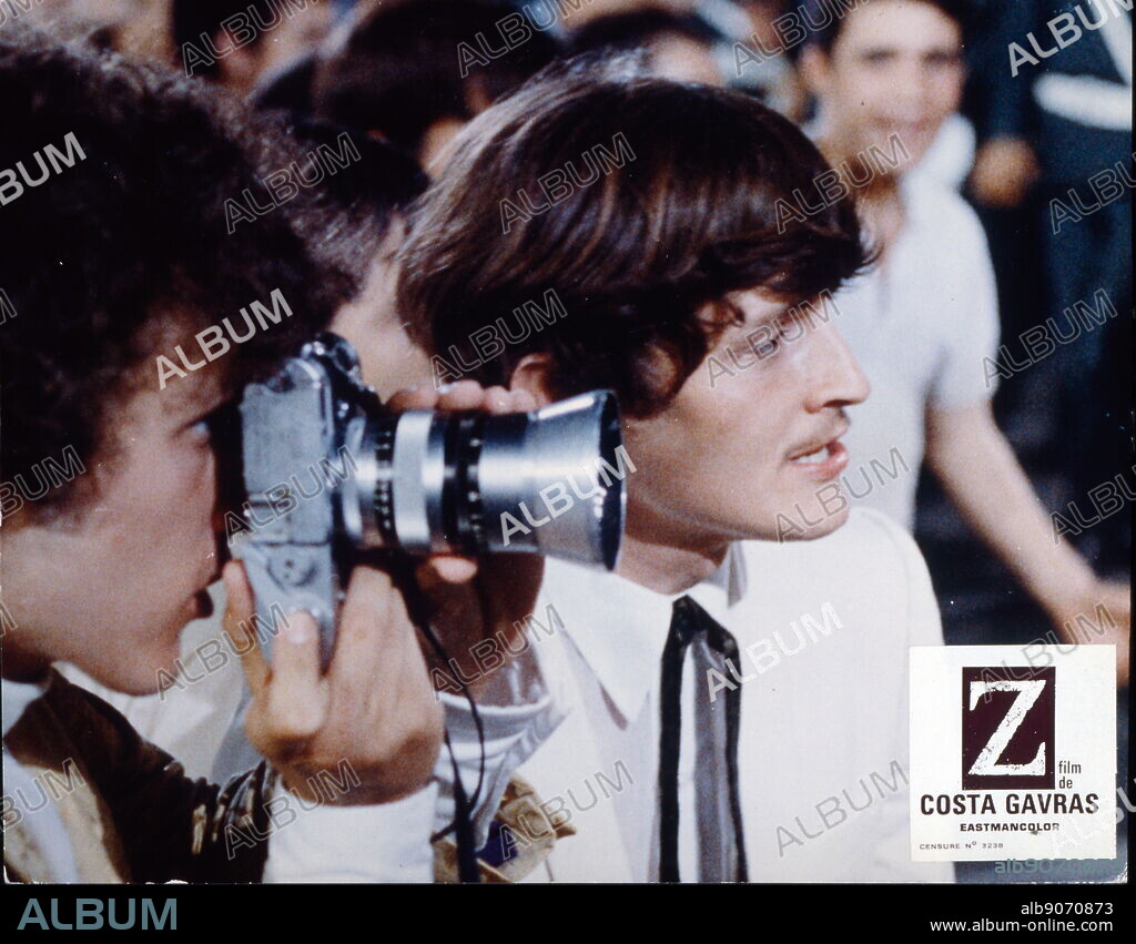 Film Still, from the fast-paced thriller Z (1969) by Costa-Gavras. Konstantinos Gavras, born 12 February 1933; Greek-French film director and producer, who lives and works in France. He is known for films with overt political themes, most famously the fast-paced thriller Z (1969); Algerian-French epic political thriller film directed by Costa-Gavras, with a screenplay by Gavras and Jorge Semprun, based on the 1966 novel of the same name by Vassilis Vassilikos. The film presents a thinly fictionalized account of the events surrounding the assassination of democratic Greek politician Grigoris Lambrakis in 1963.