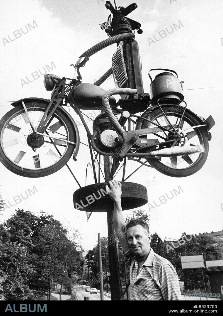 Stockholm 1966-06-30. Denna motorcykel från efterkrigsåren på 40-talet, en svarting från Husqvarna, har snurrat som vindflöjel i sex år ovan Roland Wallqvist Eftr, skrotfirman för bilar och motorcyklar i hörnet av Klara Strand och Rörstrandsgatan vid Karlberg som rivs som bäst för Essingeleden. Skrotfirmans ägare är gamle mc-mästaren Berthold Ericsson som här ses vid sin motorcykel som nu deponeras på Moderna Museet. Foto: Gunnar Forsberg / DN / TT / Kod: 192. ** SvD OUT **.