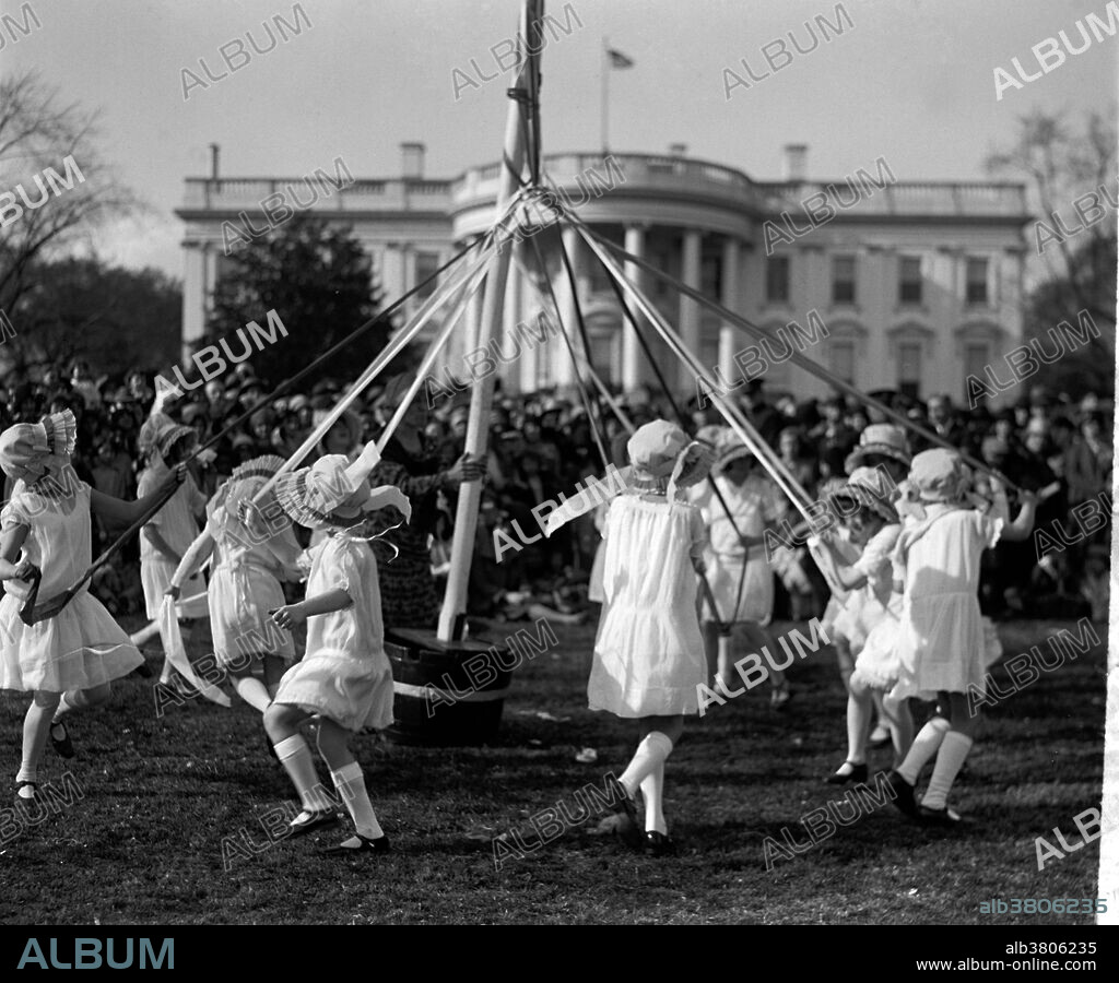 May Pole dance, at the Easter egg roll event sponsored by the White House. Maypole dancing is a form of folk dance from Germany, England, and Sweden. Historians believe the first maypole dance originated as part of Germanic pagan fertility rituals. Originally, the dancers danced around a living tree. While dancers usually perform this dance in the spring on May 1 or May Day, those in Sweden perform it during their midsummer celebrations. In the United States, the Easter Egg Roll is an annual event, and is held on the White House lawn each Easter Monday for children and their parents. The Egg Roll itself is a race, where children push an egg through the grass with a long-handled spoon. Surrounding events include appearances by White House personalities in Easter Bunny costumes, speeches and book-reading by Cabinet secretaries, and exhibits of artistically-decorated eggs. Photographed by the National Photo Company, April 1, 1929.